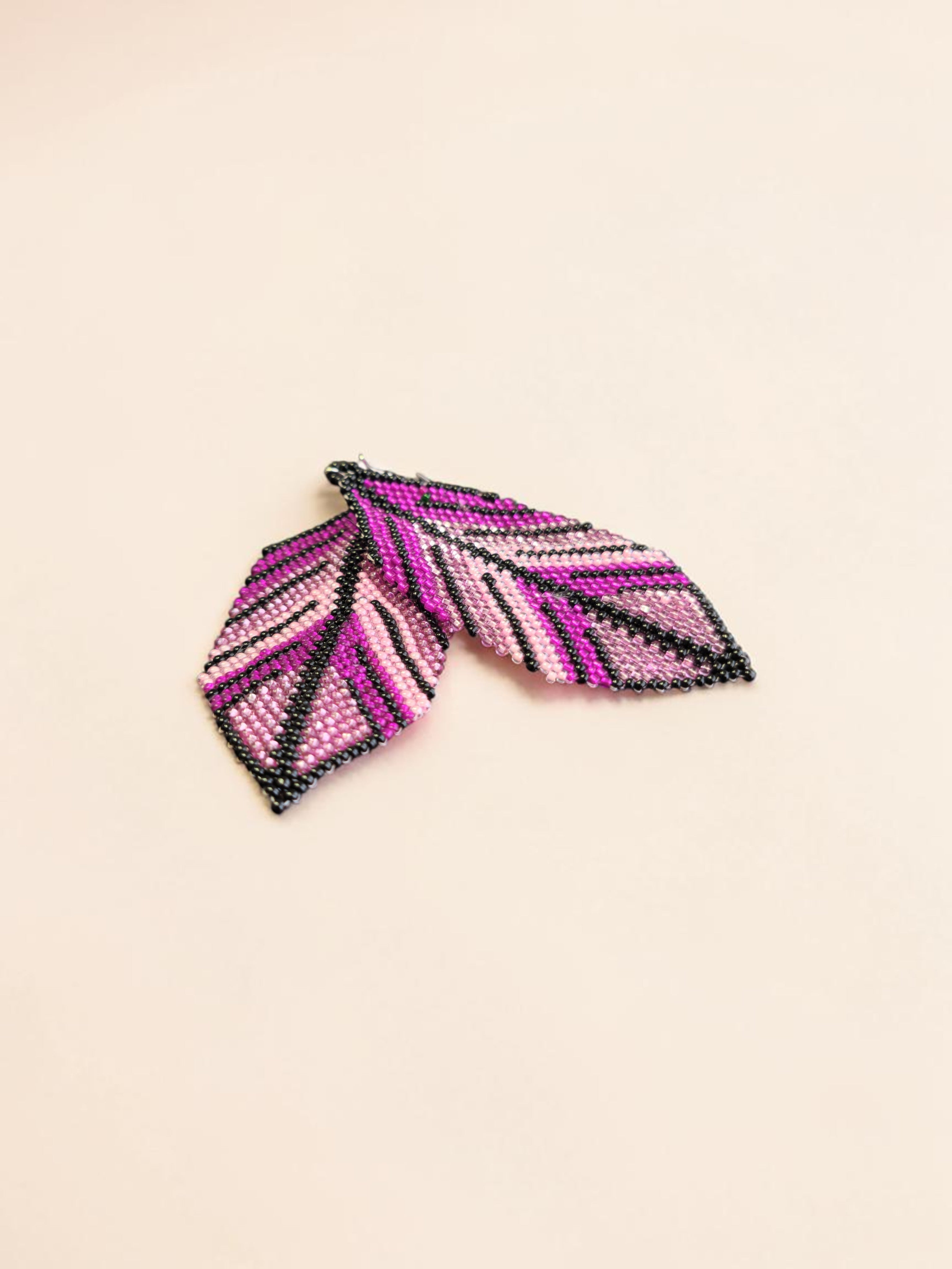 Beaded hair clip with pink and black pattern on a beige background