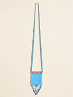 Blue beaded necklace with colorful accents on a beige background