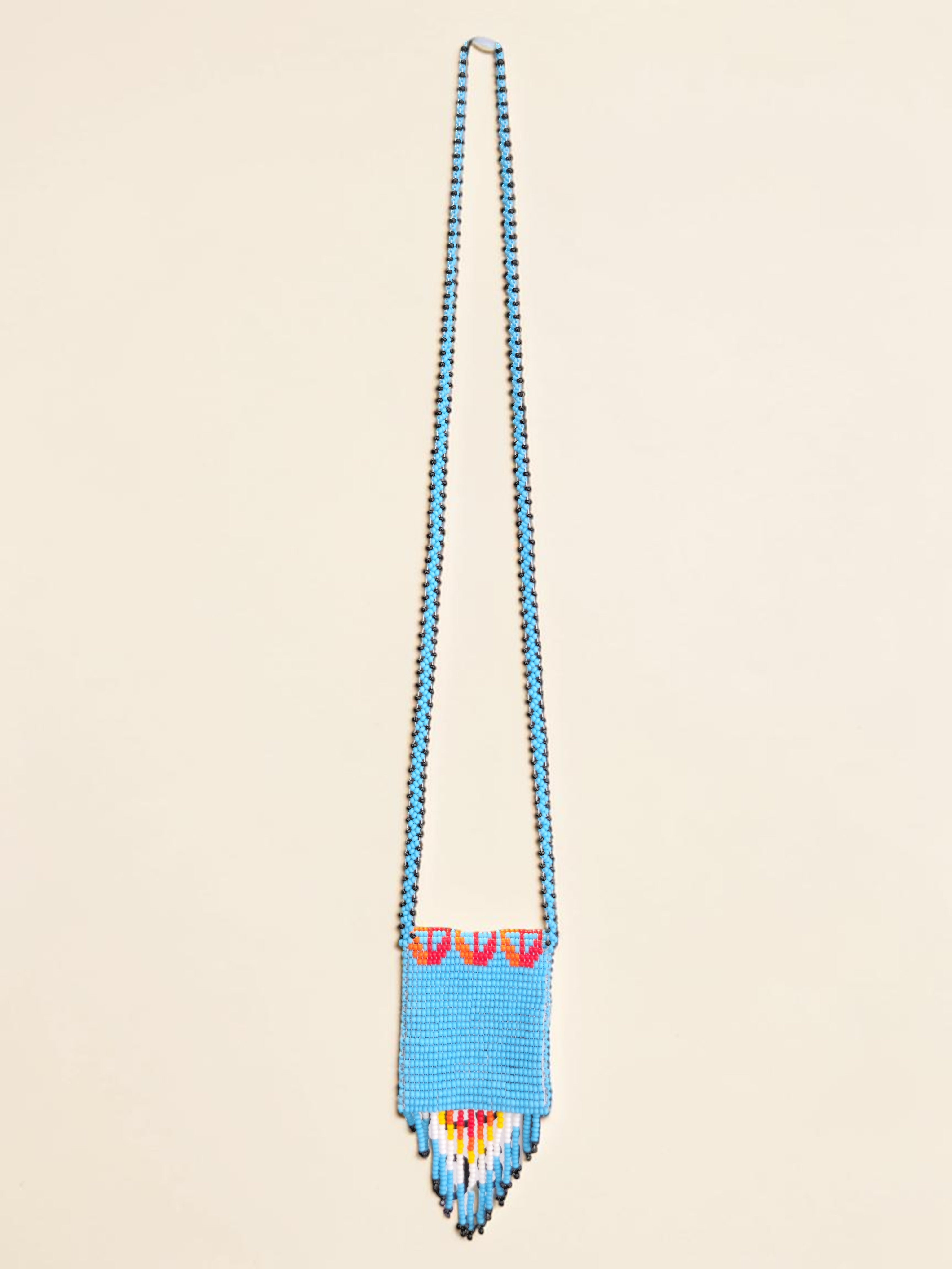 Blue beaded necklace with colorful accents on a beige background