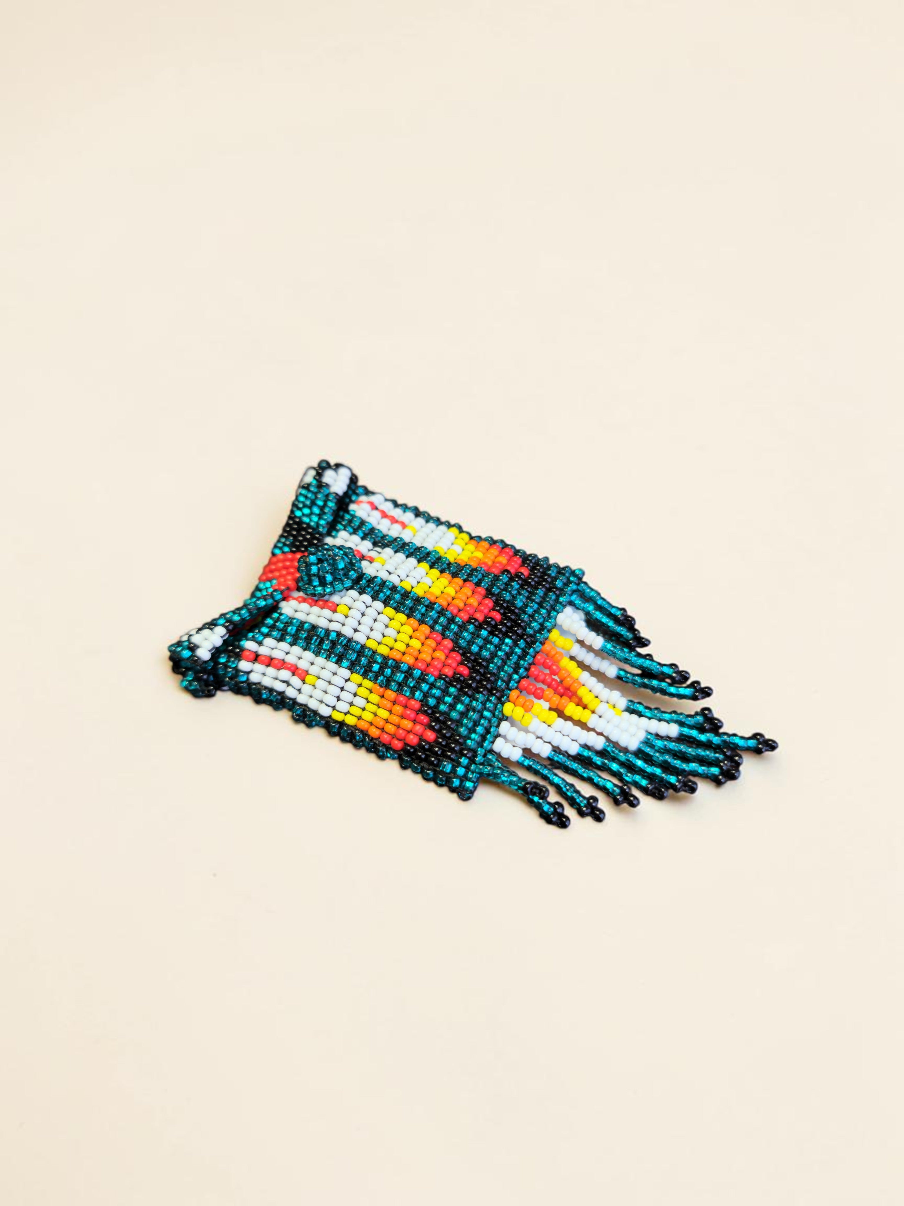 Colorful beaded clutch with fringes on a beige background