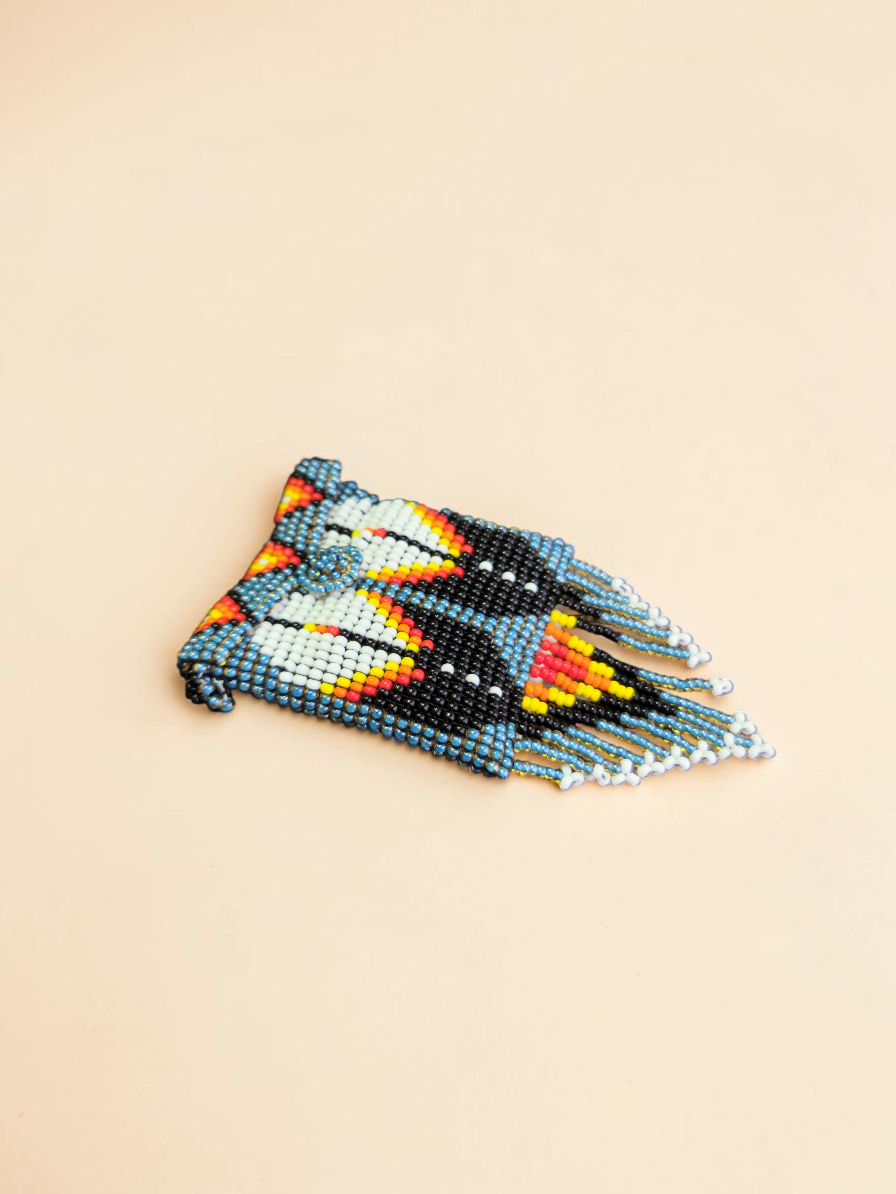 Beaded butterfly brooch on a beige background