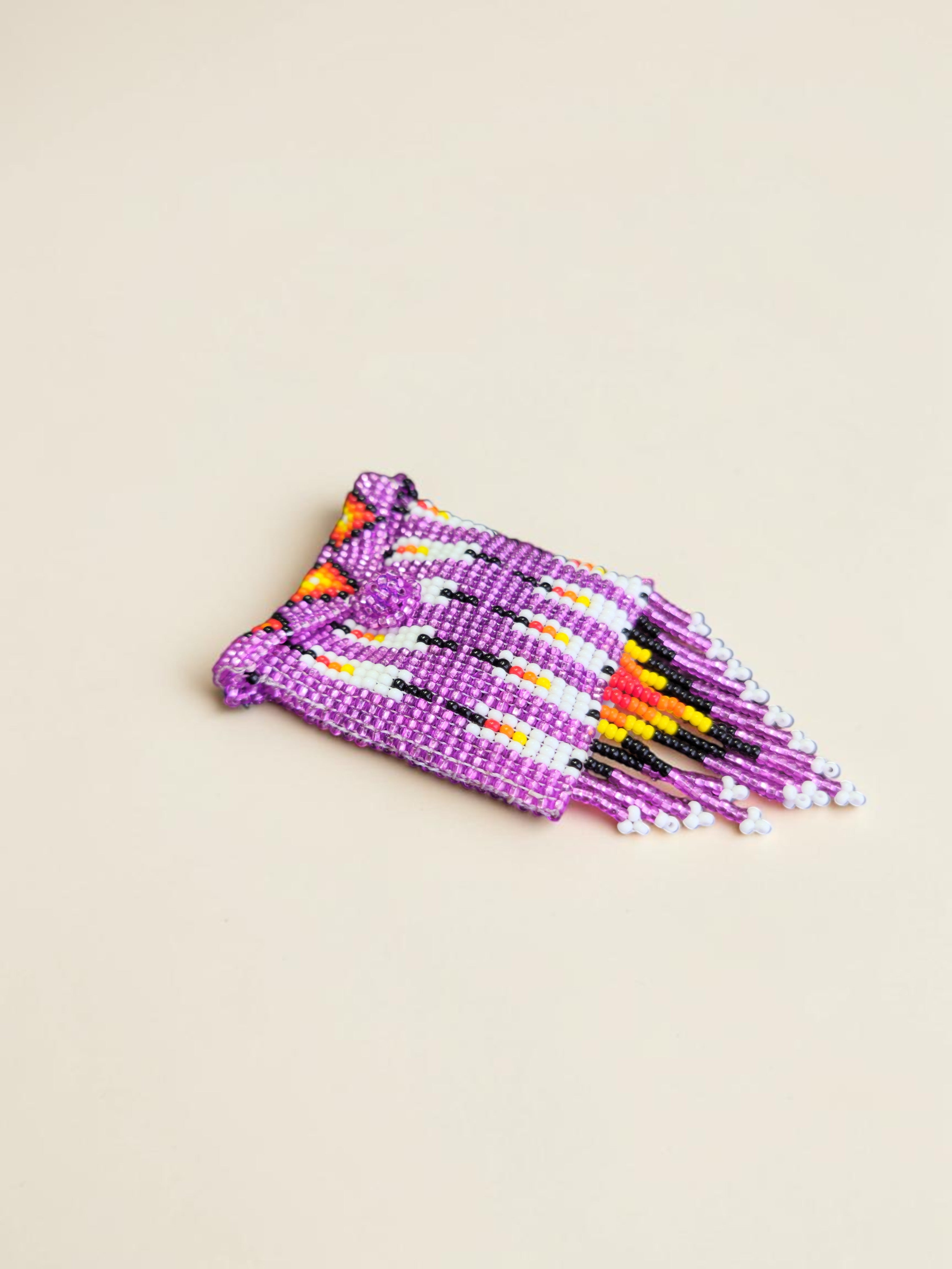 Purple beaded bracelet with colorful patterns on a beige background