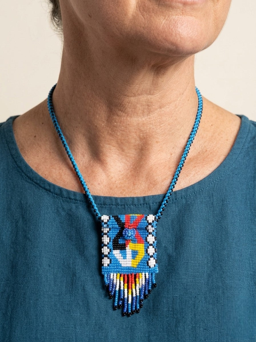Person wearing a blue beaded necklace with a colorful pendant on a beige background