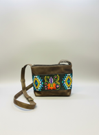 Brown leather handbag with colorful embroidery on a white background