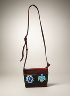 Handbag with a decorative strap on a neutral background